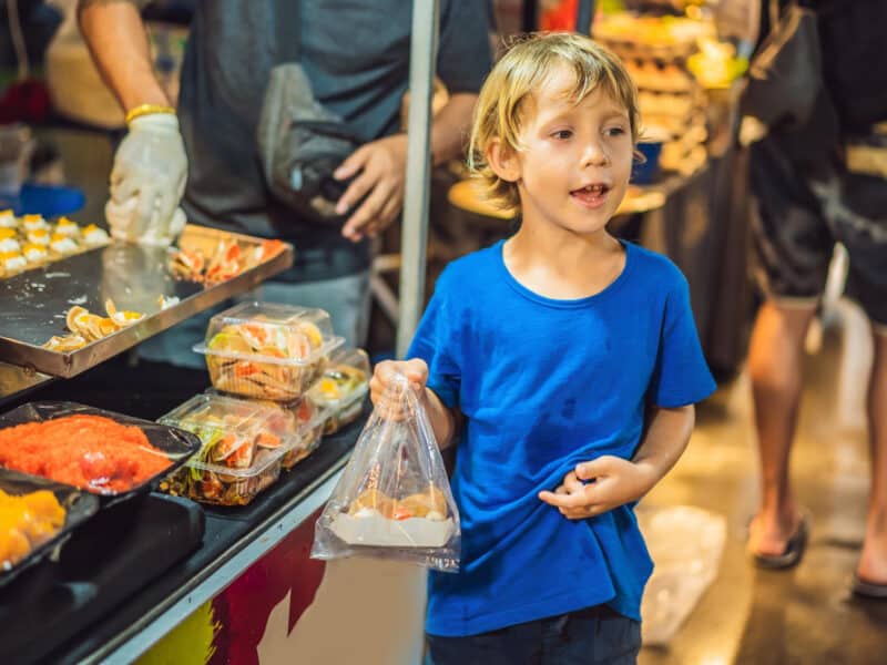 kleiner-junge-tourist-auf-dem-asiatischen-lebensmittelmarkt-der-walking-street kleiner-junge-tourist-auf-dem-asiatischen-lebensmittelmarkt-der-walking-street